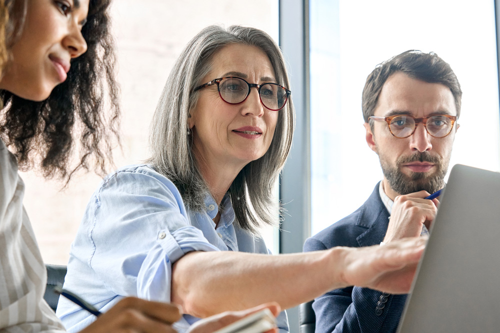 Business professionals reviewing work together on a laptop